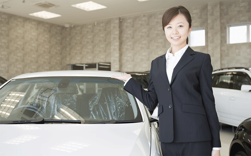 札幌のカーリース店舗で車を紹介する女性